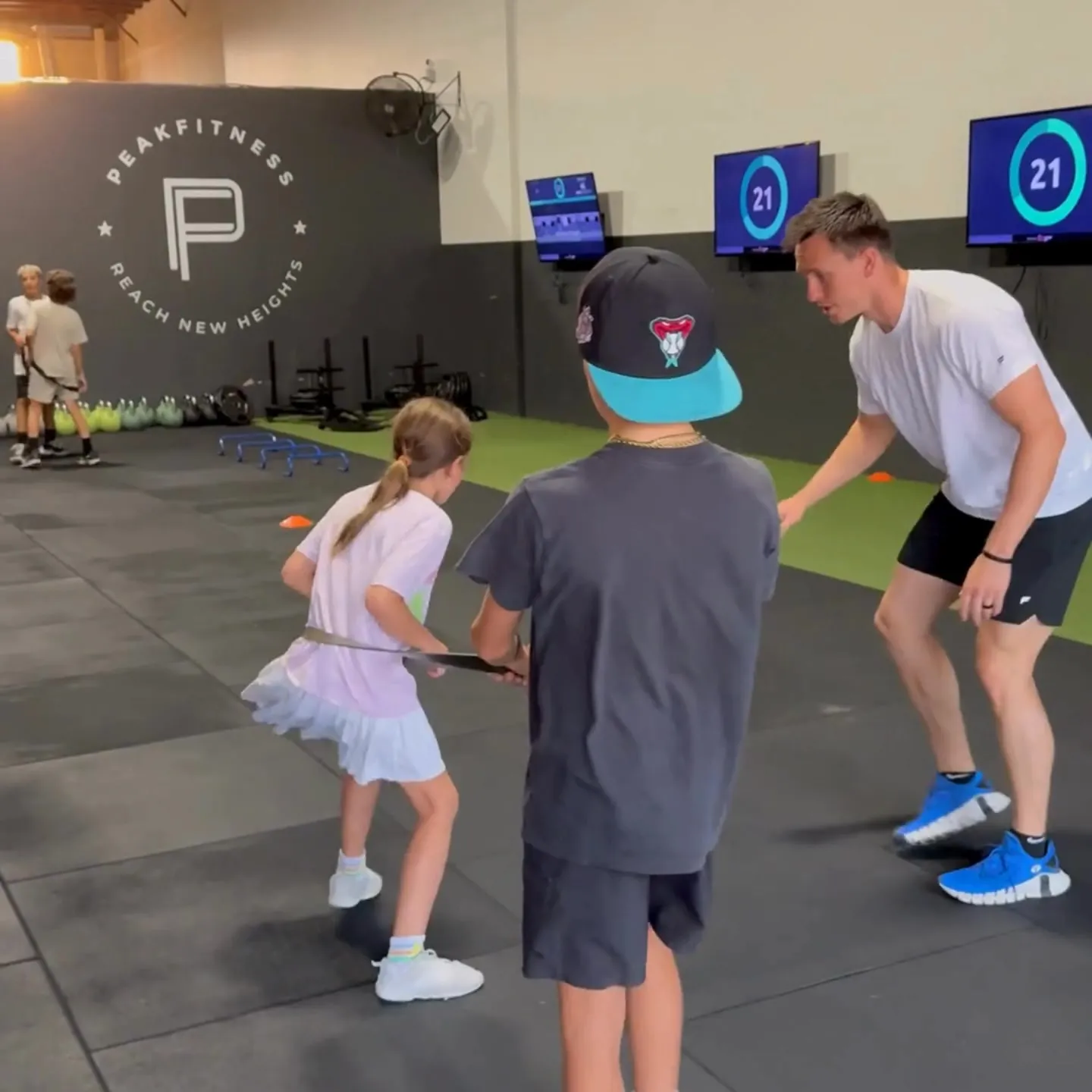 Peak Fitness coach running agility drills with youth athletes in Orem