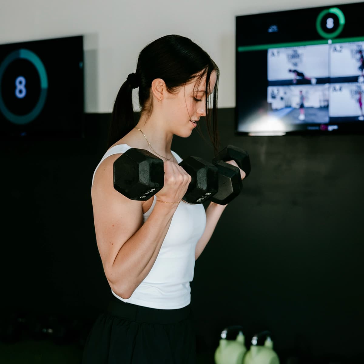Member doing dumbbell curls at Peak Fitness in Orem